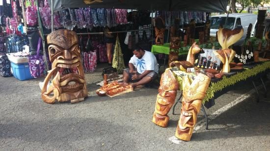 Carved wooden tiki statues for sale at an Aloha Stadium Swap Meet stall