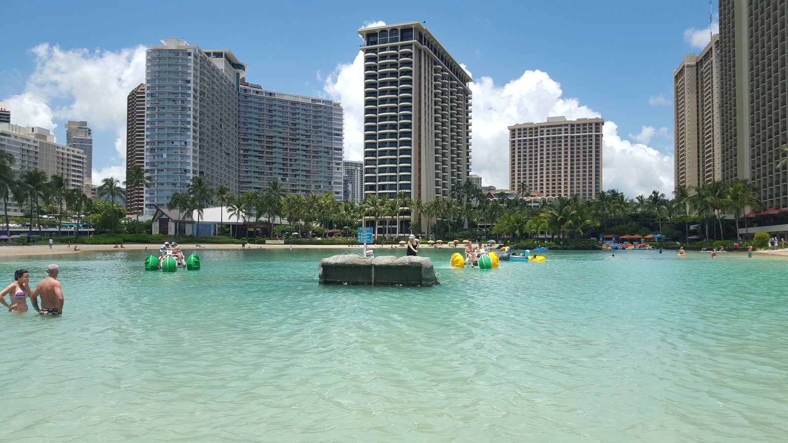 Duke Kahanamoku Lagoon with pedal boats and the Hilton Hawaiian Village towers behind