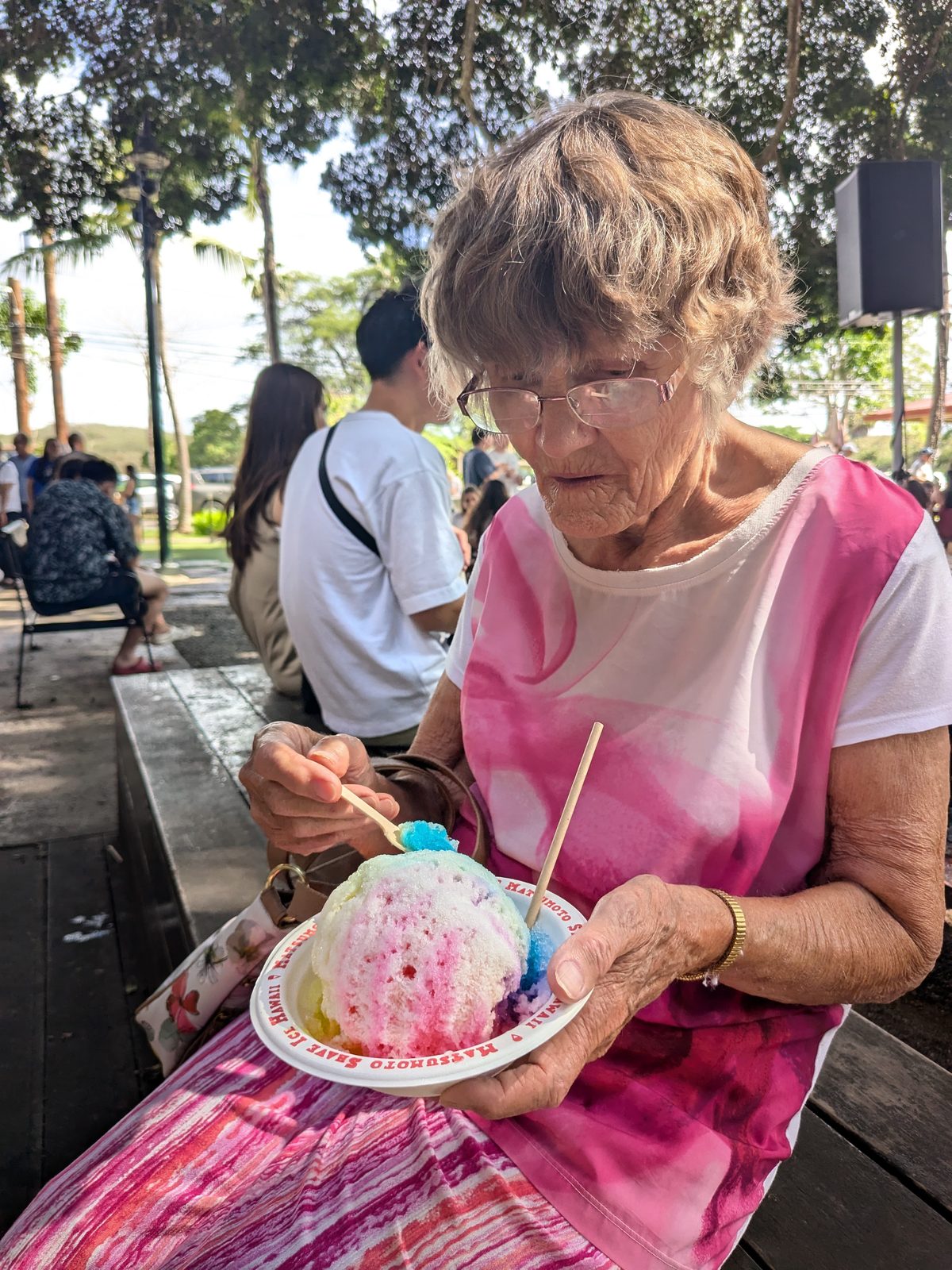 A rainbow shave ice from Matsumoto's on the bench in Haleiwa, November 2024