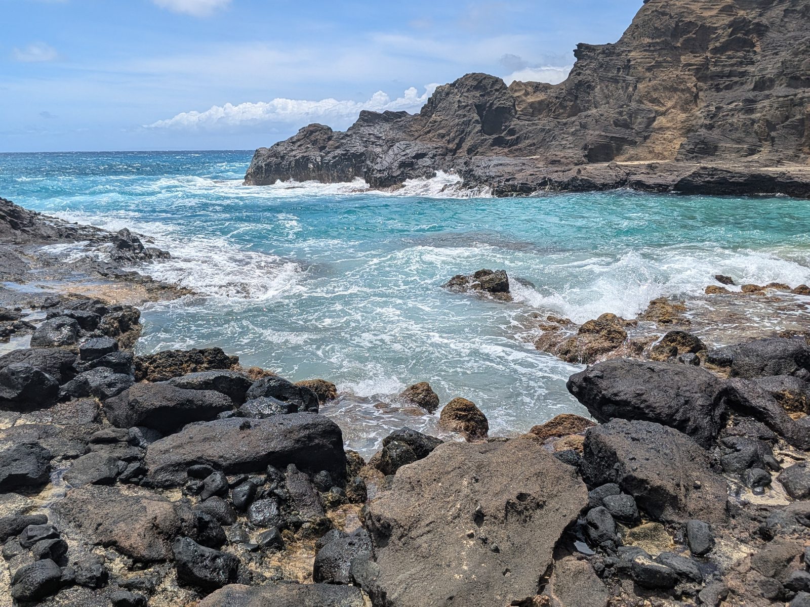 Turquoise surf washing over the lava rock at Halona, May 2025