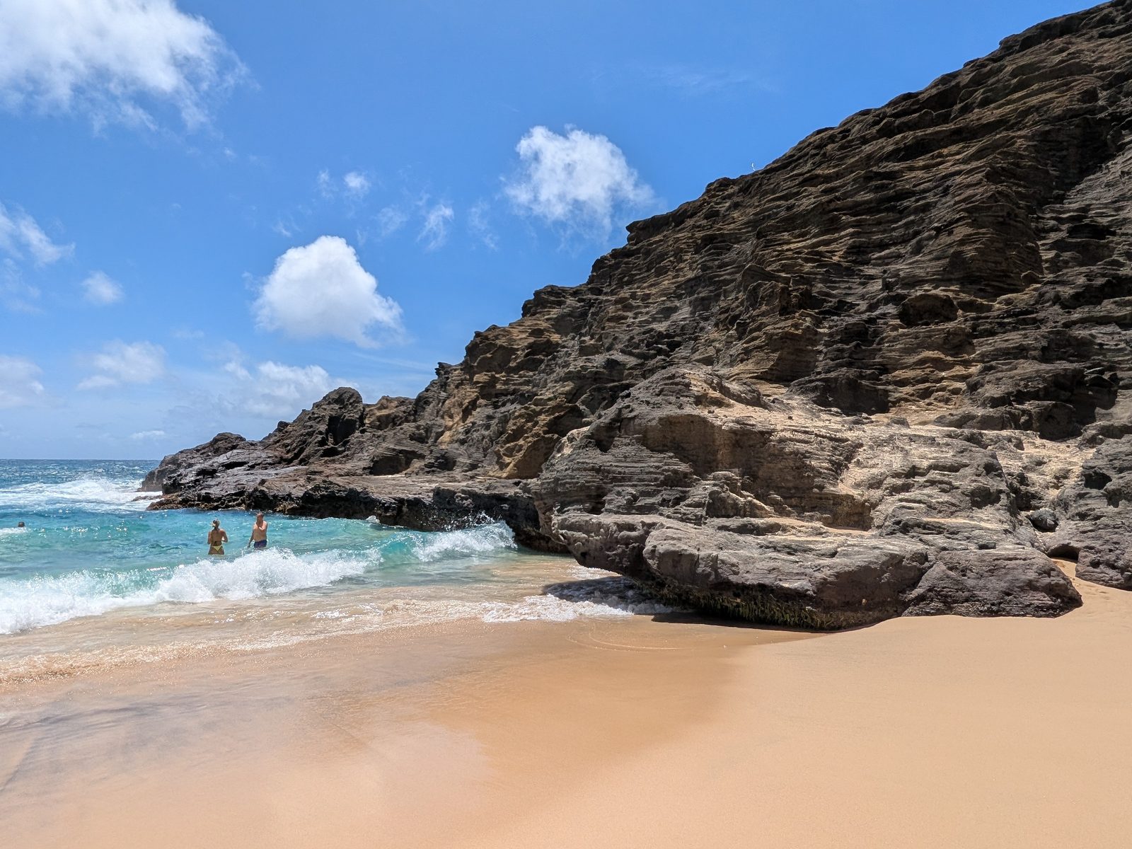 Halona Cove’s layered cliff wall rising from the sand