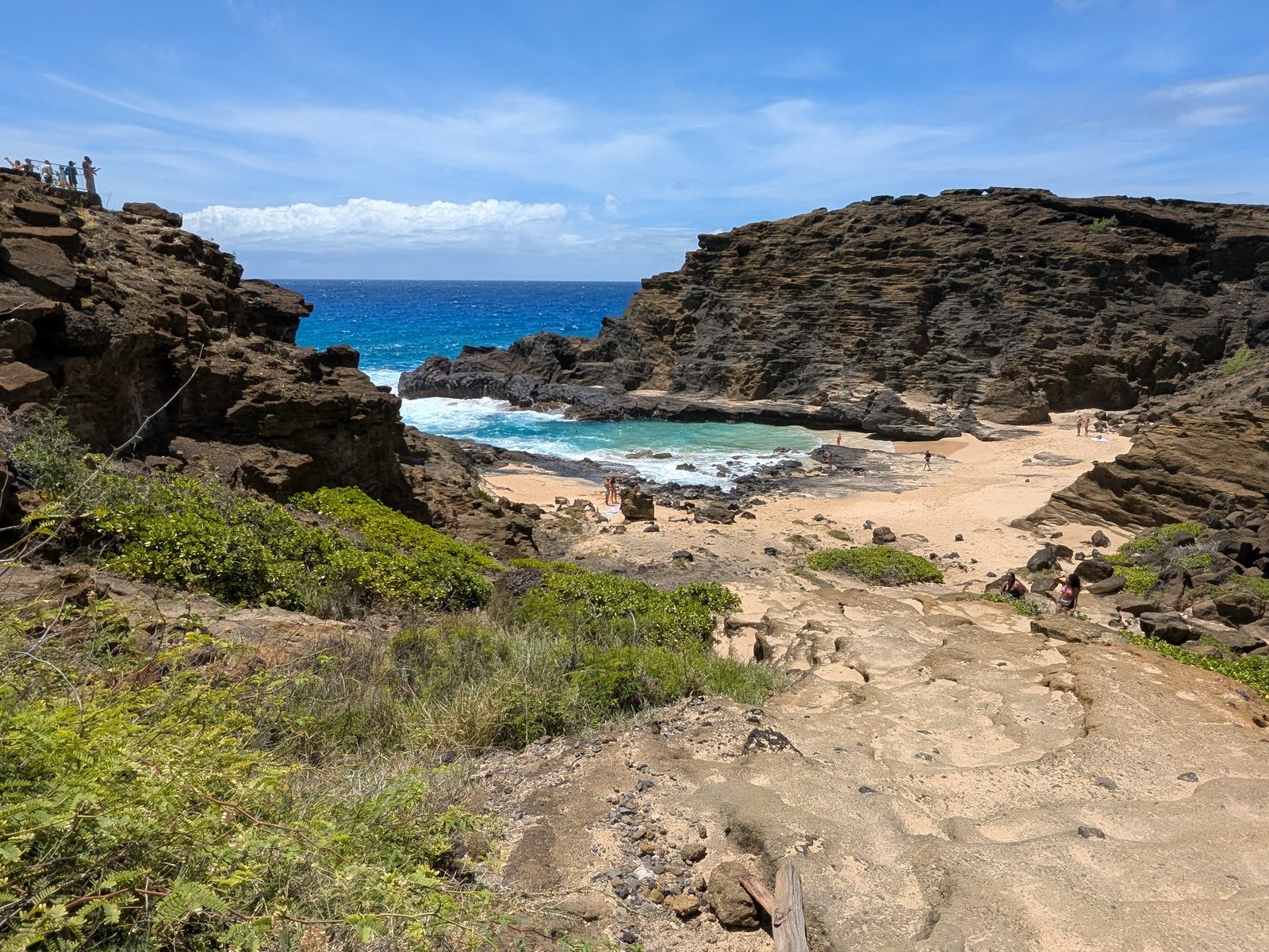 Halona Cove from the trail above — a small sandy cove tucked between lava cliffs, May 2025