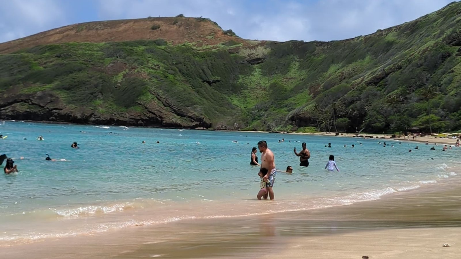 Hanauma Bay at beach level, snorkelers across the reef
