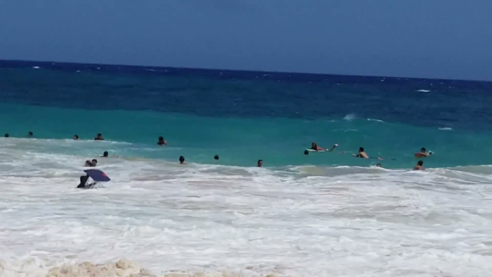 Bodyboarders in turquoise water at Sandy Beach
