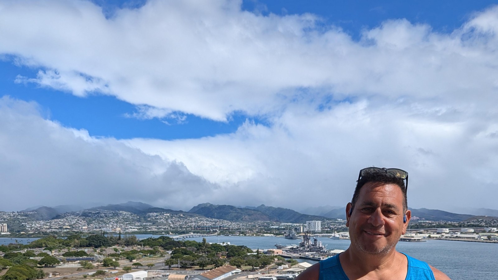 Michael on the Ford Island control tower with the USS Missouri at her berth in Pearl Harbor behind him