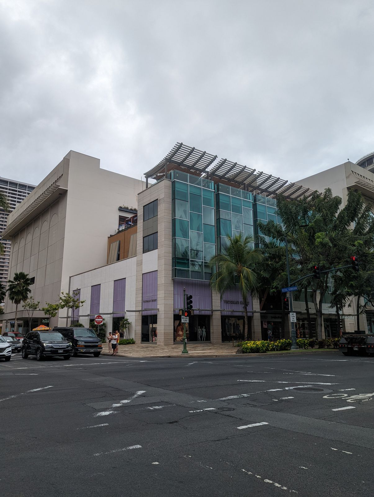 Waikiki Beach Walk's storefronts seen from across Kalakaua Ave, May 2022