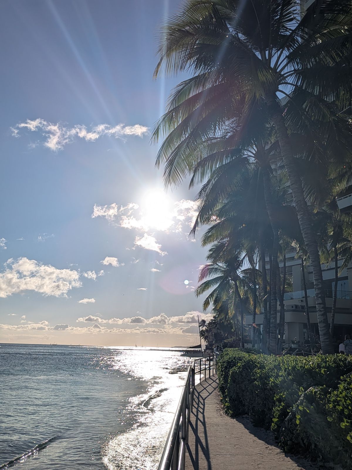 Sunset over the water from the Waikiki beachfront promenade, May 2025
